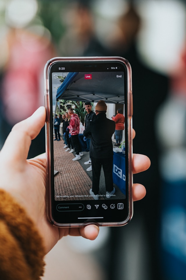 Una persona riprende un video in diretta utilizzando il proprio smartphone.
