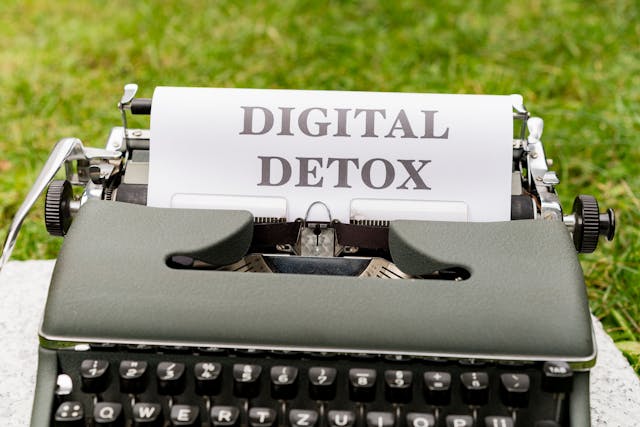 Una macchina da scrivere verde con la scritta "digital detox" su un foglio.