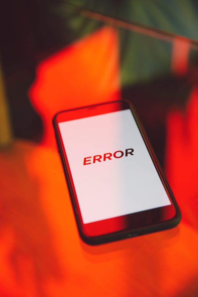 Un smartphone negru afișează eroarea de text pe un ecran alb.