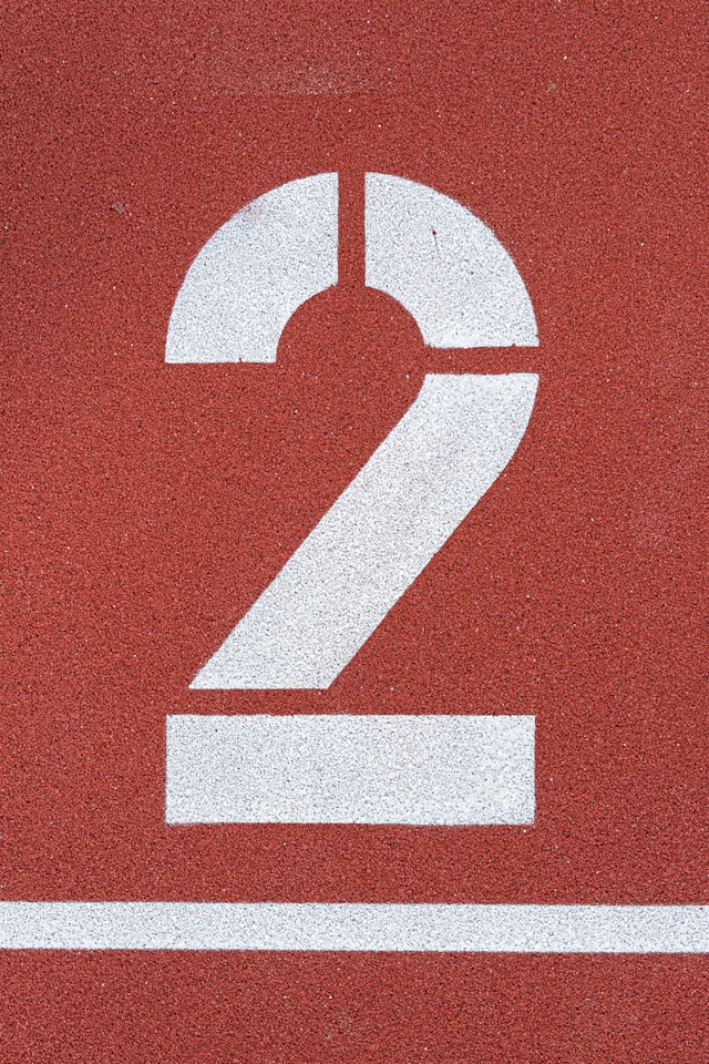 Het cijfer twee in witte verf op een rood oppervlak.