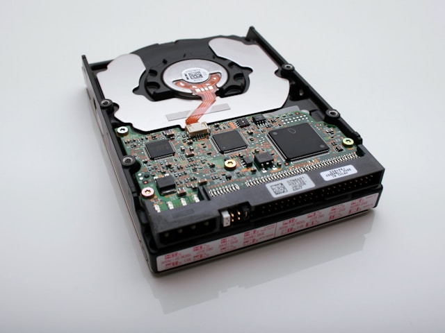 Foto close-up bagian dalam hard disk drive.
