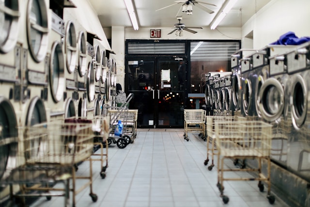 A laundromat with multiple washing machines and carts.