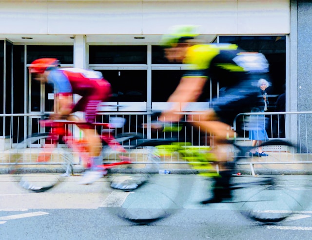 A blurry close-up of two cyclists on a street. 