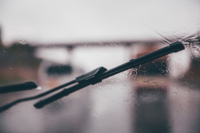 A close-up of a black wiper on a windshield.