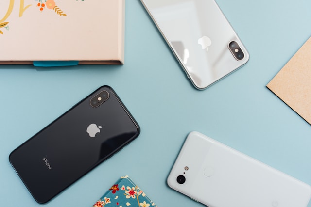 De achterkant van een zwarte iPhone X, een grijze iPhone X en een witte Google Pixel 2 XL.