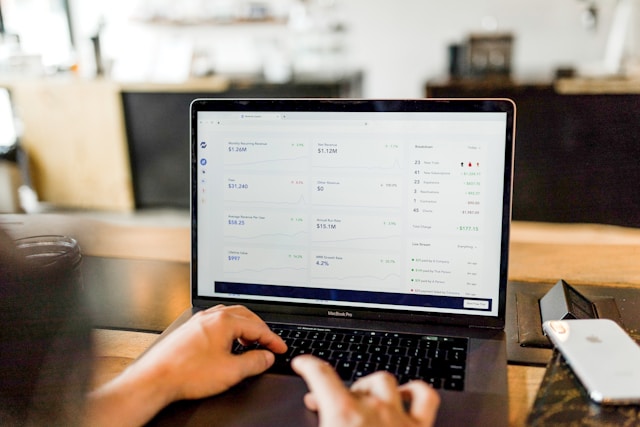 A person looks at a dashboard on their gray Macbook Pro.