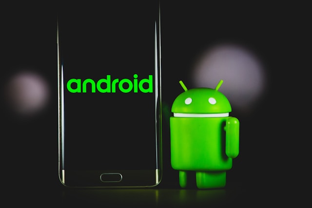 Um telemóvel Samsung preto apresenta o texto "Android" ao lado da mascote verde do Android.