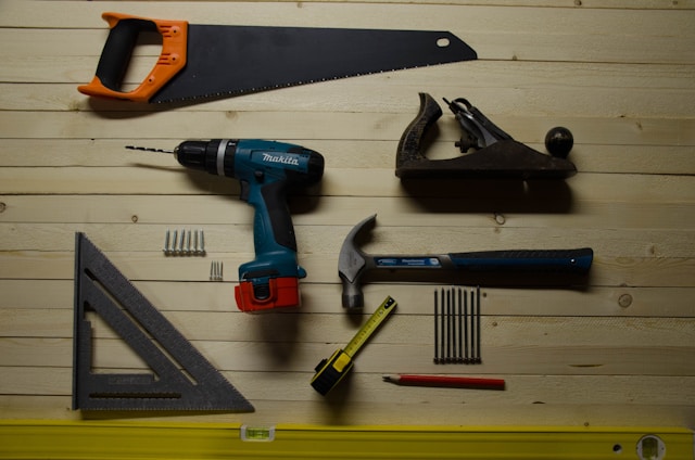 An assortment of power tools and accessories on a wooden wall.