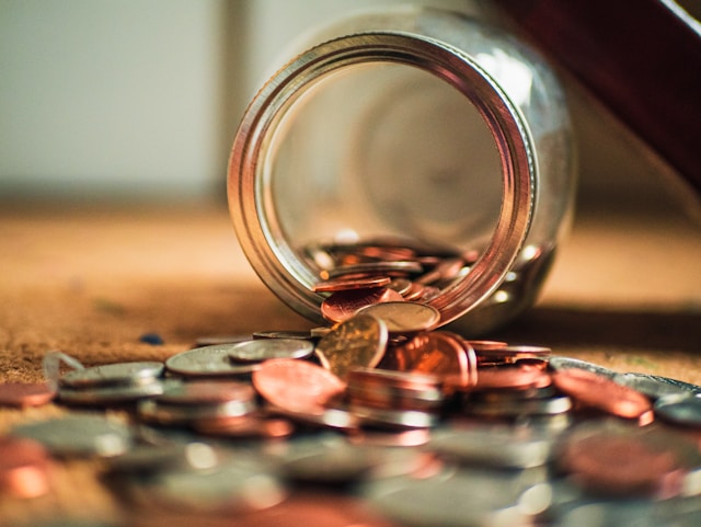 Een close-up van verschillende munten en een glazen pot.