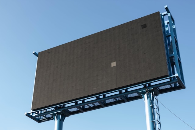 Un cartellone pubblicitario vuoto con uno schermo nero su una cornice metallica blu.