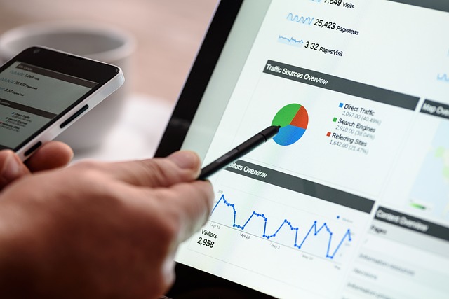 A person points a black stylus on a pie chart on a display.