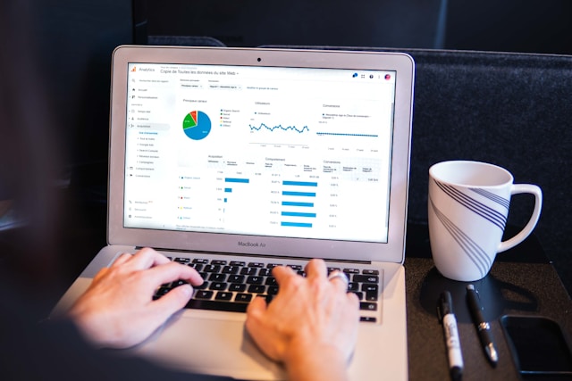 A person checks their Google Analytics dashboard on a gray MacBook Air.