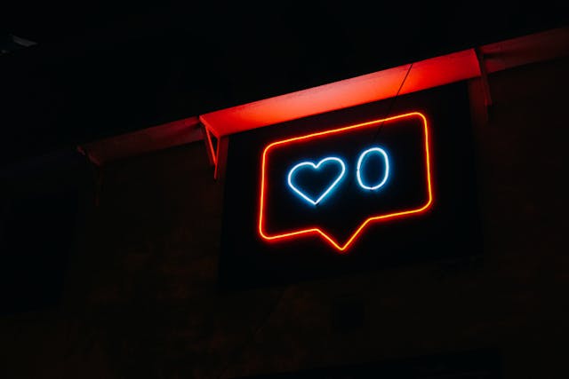 A red neon chat bubble with a blue neon heart and zero.