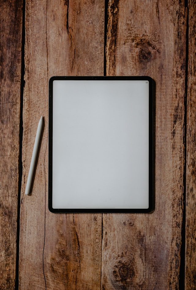 A blank page on a black iPad with a white Apple pencil next to it