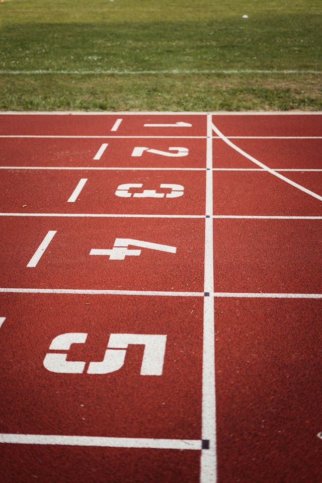 Een close-up van de finishlijn op een rode atletiekbaan.