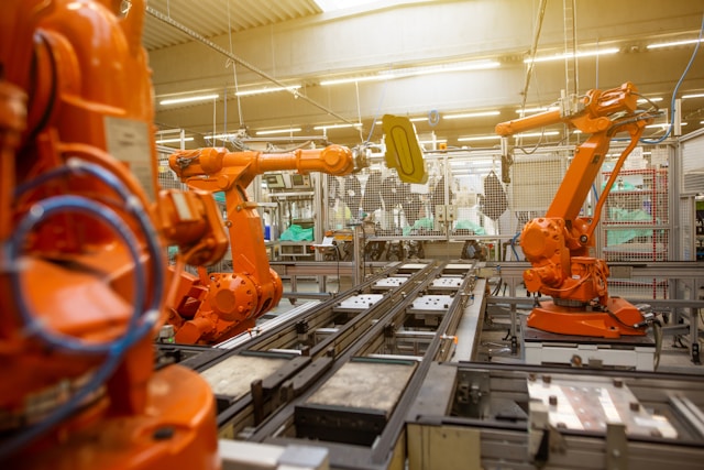 Een close-up van verschillende oranjekleurige machines in een fabriek.