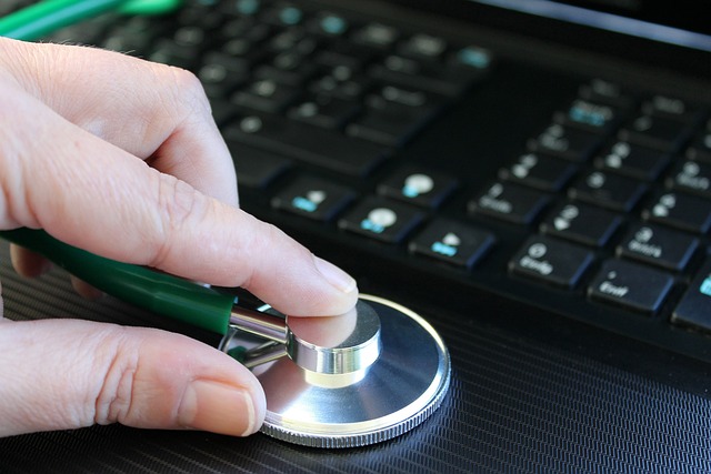 Une personne tient un stéthoscope sur une surface noire.