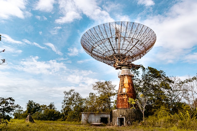 Uma velha antena parabólica no meio do mato.