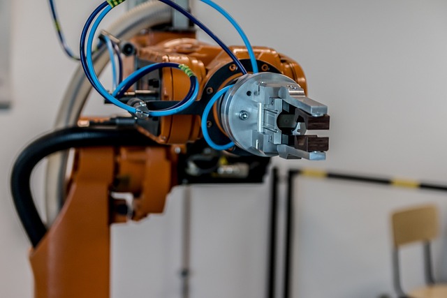 Primo piano di un braccio robotico grigio e arancione con accenti neri.