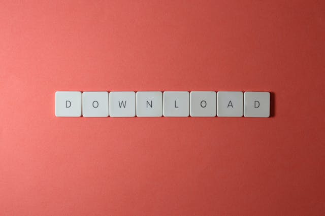 A close-up of several white keys that spell the word “download.”