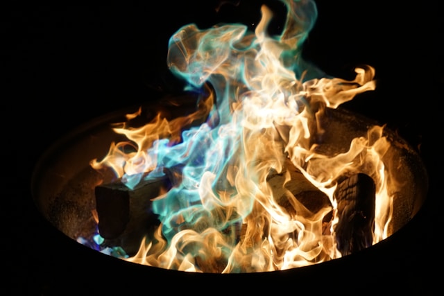 Primo piano di un incendio con fiamme arancioni e blu.