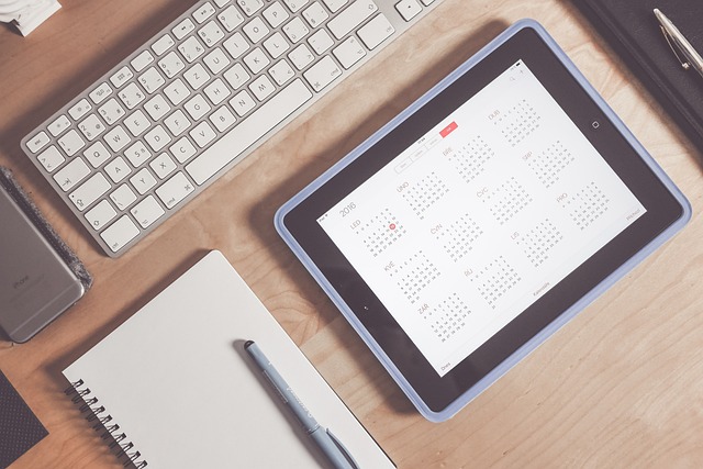 A tablet on a desk displays a calendar app.