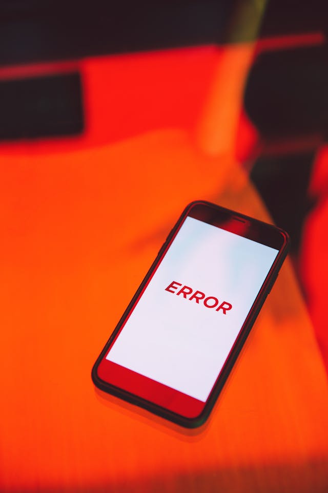 Un téléphone noir avec un écran blanc et le mot "error" en rouge.