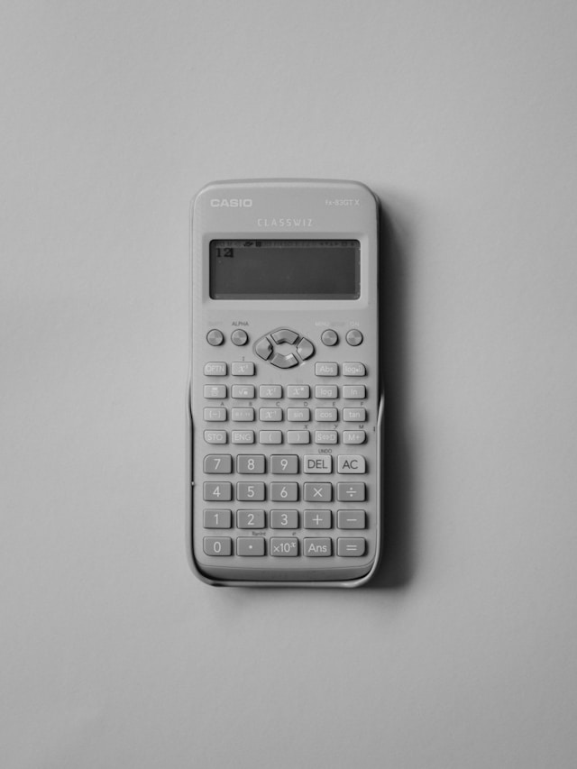 A close-up of a white scientific calculator on a white background.