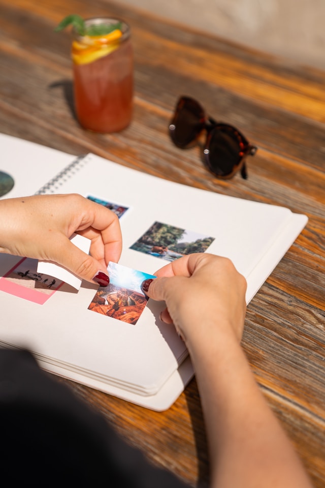 Una persona pega una foto en un libro.