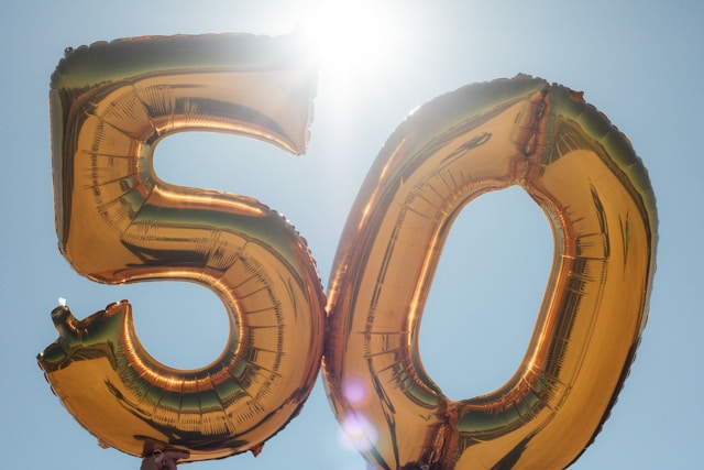 Primer plano de dos globos dorados que representan el número 50.